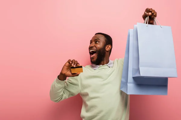 Έκπληκτος Αφρικανός Αμερικανός Άνθρωπος Πιστωτική Κάρτα Και Τσάντες Ψώνια Κοιτάζοντας — Φωτογραφία Αρχείου