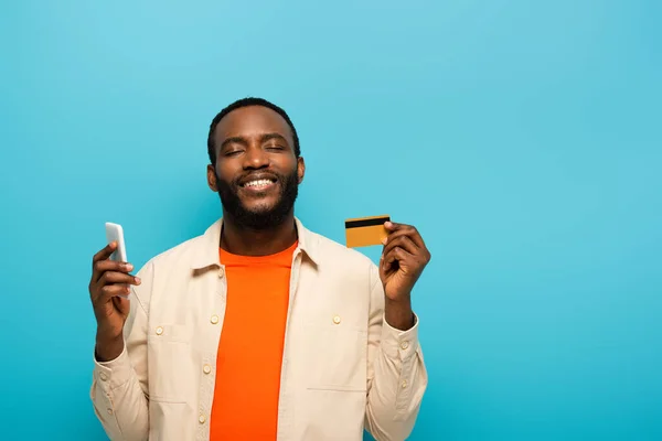 Glimlachende Afro Amerikaanse Man Met Credit Card Terwijl Het Gebruik — Stockfoto