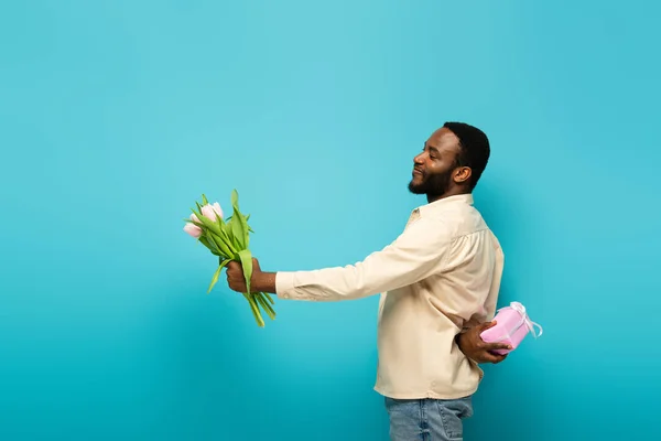 Zâmbind African American Prezentând Lalele Timp Ascunde Cutie Cadou Spatele — Fotografie, imagine de stoc