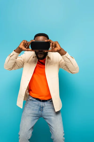 African American Man Adjusting Headset Blue Background — Stock Photo, Image