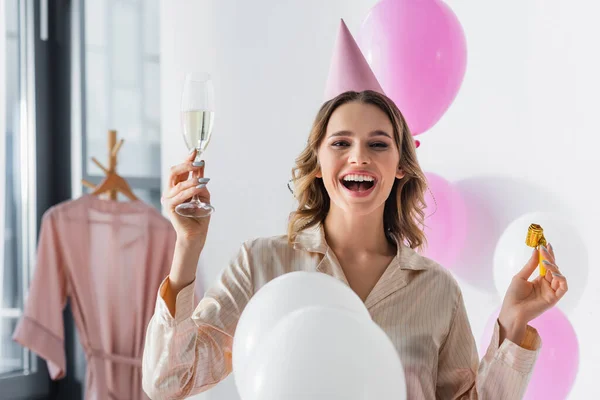 Smiling Woman Party Horn Champagne Looking Camera Balloons Home — Stock Photo, Image