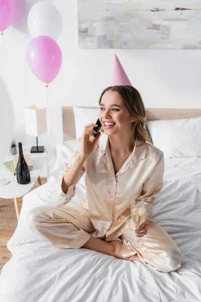 Glimlachende Vrouw Met Champagne Party Cap Praten Smartphone Bed — Stockfoto