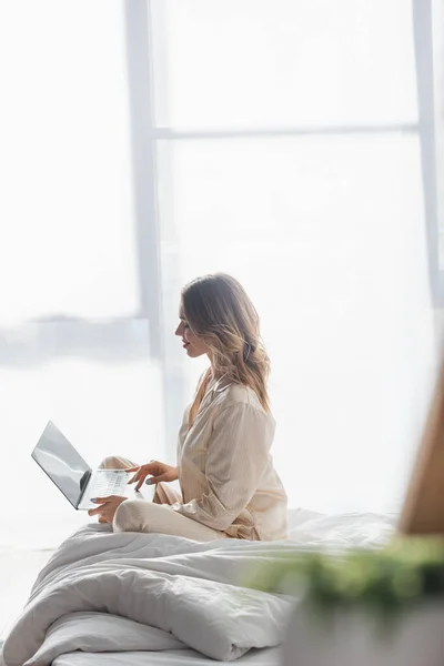 Vista Lateral Mujer Sonriente Usando Ordenador Portátil Dormitorio — Foto de Stock