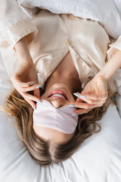 Κάτοψη Της Χαρούμενης Γυναίκας Μάσκα Ύπνου Ξαπλωμένη Στο Κρεβάτι — Φωτογραφία Αρχείου