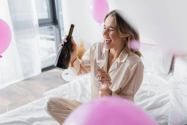 Donna Positiva Possesso Vetro Bottiglia Champagne Sul Letto Vicino Palloncini — Foto Stock