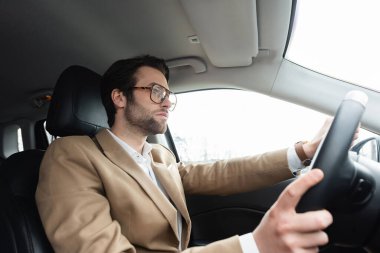 bearded man in glasses driving modern car  clipart