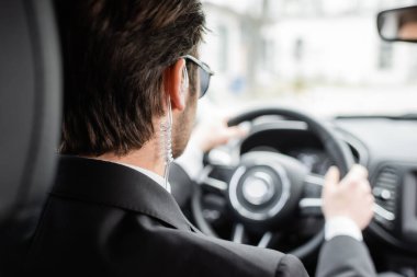 back view of bodyguard driving modern automobile 
