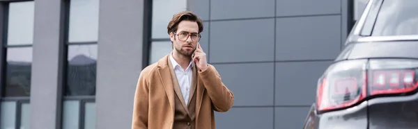 Confident Businessman Glasses Beige Coat Talking Phone Car Banner — Stock Photo, Image