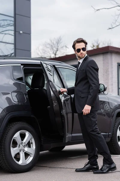 Guardaespaldas Barbudo Traje Gafas Sol Con Auricular Seguridad Abriendo Puerta — Foto de Stock