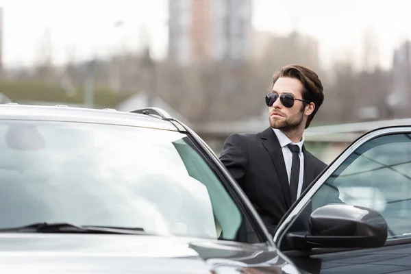 Hombre Negocios Barbudo Con Traje Gafas Sol Sentado Coche Moderno —  Fotos de Stock