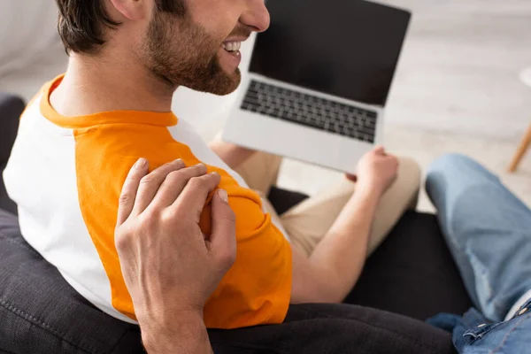 stock image Cropped view of father hugging smiling man with blurred laptop 