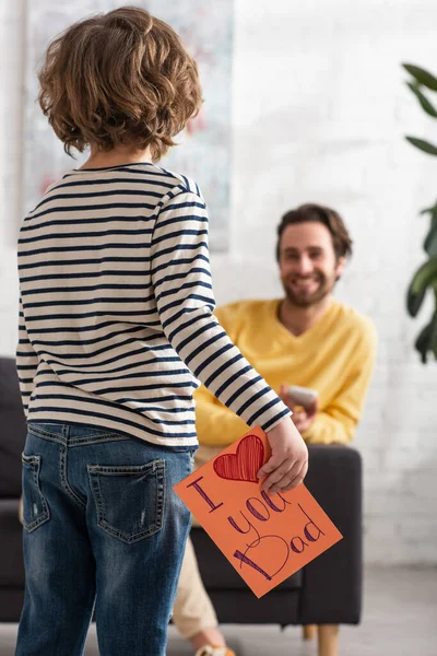 Boy Holding Gift Card Love You Dad Lettering Blurred Father — Stock Photo, Image