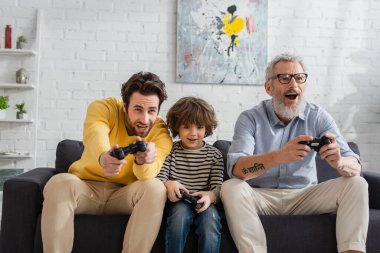 KYIV, UKRAINE - 12 Nisan 2021: Erkekler ve çocuklar evde video oyunu oynuyorlar 