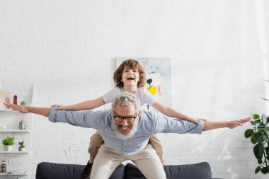 Mutlu olgun bir adam evde çocukla oynuyor. 