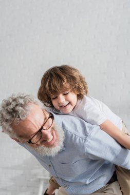Gülümseyen adam ve torun evde oynuyorlar. 
