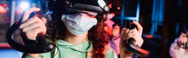 VR oyun sahasında tıbbi maske takan Afro-Amerikan kız manzarası.