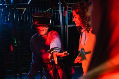 Neşeli çok kültürlü arkadaşlarının yanında vr kulaklık takan heyecanlı çocuk.