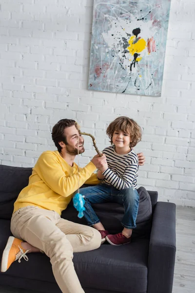 Sorrindo Homem Abraçando Criança Jogando Brinquedo Pesca — Fotografia de Stock