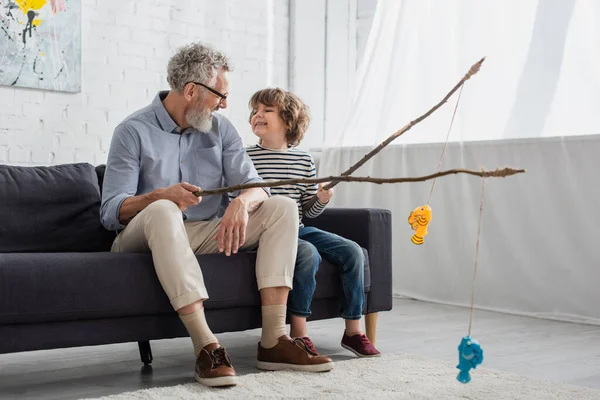 Lächelnder Opa Und Junge Schauen Einander Beim Spielzeugfischen — Stockfoto