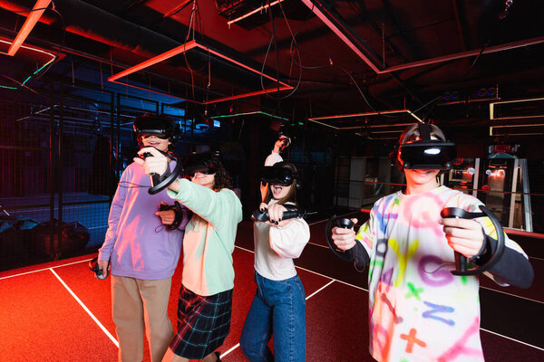 cheerful interracial teenagers having fun in vr play zone
