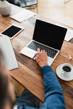 Bilgisayarda dijital tablet ve kahve bardağının yanında çalışan serbest çalışanın kısmi görüntüsü