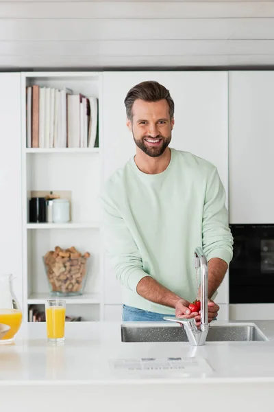 Hombre Sonriendo Cámara Mientras Lava Tomates Cherry Cocina — Foto de Stock