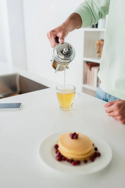 Cropped View Man Pouring Green Tea Tasty Pancakes Blurred Foreground — Stock Photo, Image