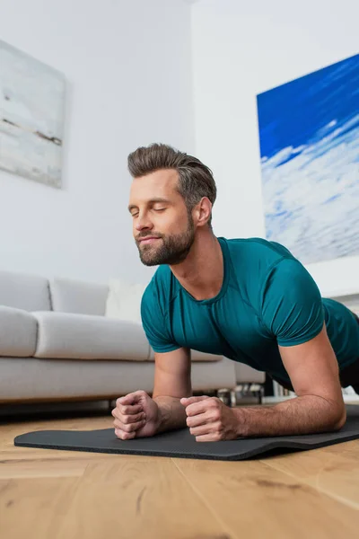 Homem Esportivo Exercendo Prancha Posar Com Olhos Fechados — Fotografia de Stock