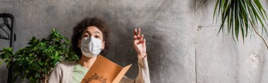 Afro-Amerikalı tıbbi maskeli müşteri, kafeteryada menü tutuyor. 