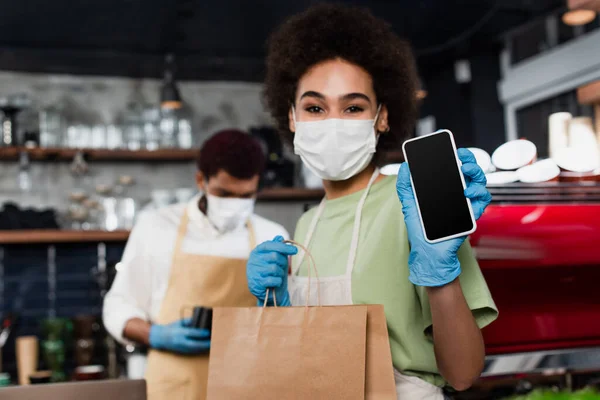 Smartphone Hand African American Barista Medical Mask Holding Paper Bag — Stock Photo, Image
