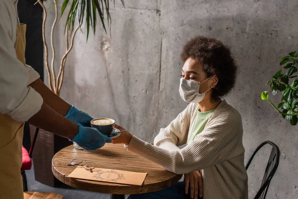 Cameriere Afroamericano Guanti Lattice Possesso Caffè Vicino Alla Donna Maschera — Foto Stock