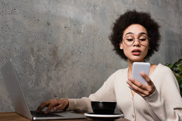 Africano Mulher Americana Usando Laptop Smartphone Perto Xícara Café — Fotografia de Stock