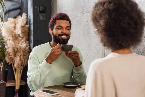 Kahveli Gülümseyen Afro Amerikan Adam Kafede Bulanık Kız Arkadaşının Yanında — Stok fotoğraf