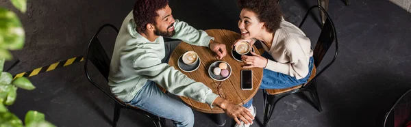 コーヒーと陽気なアフリカ系アメリカ人のクーペのオーバーヘッドビュー日付カフェで バナー — ストック写真