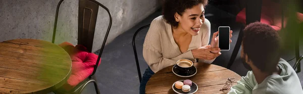 Smiling African America Woman Showing Smartphone Boyfriend Coffee Macaroons Cafe — Stock Photo, Image