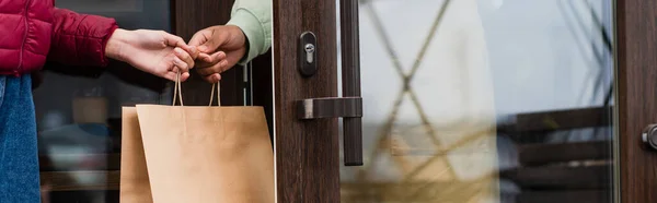 Cropped View African American Barista Giving Paper Bag Client Door — Stock Photo, Image