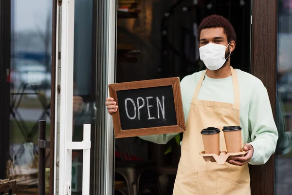 African American Barista Medical Mask Holding Coffee Chalkboard Open Lettering — Stock Photo, Image