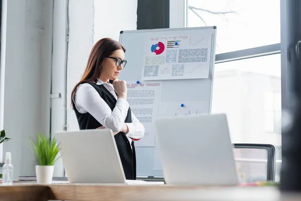 Businesswoman Standing Flipchart Blurred Laptops Office — Stock Photo, Image