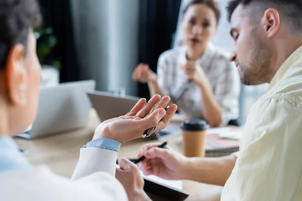 Afroamerikanische Geschäftsfrau Mit Stift Arbeitet Der Nähe Verschwommener Kollegen — Stockfoto