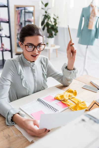 Glimlachende Ontwerper Met Potlood Papier Buurt Van Stof Mobiele Telefoon — Stockfoto