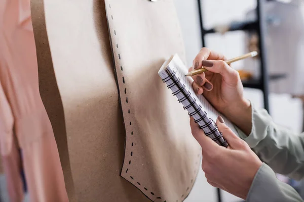 Vista Recortada Costurera Escribiendo Cuaderno Cerca Patrones Costura Taller — Foto de Stock