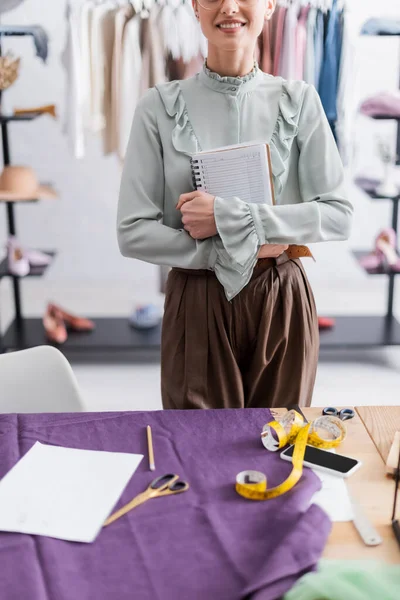Cropped View Smiling Seamstress Holding Notebook Cloth Tape Measure Cellphone — Stock Photo, Image