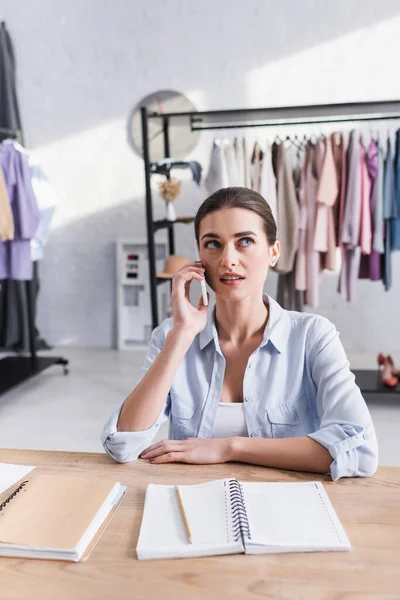 Designer Spricht Studio Neben Notizbüchern Mit Dem Handy — Stockfoto