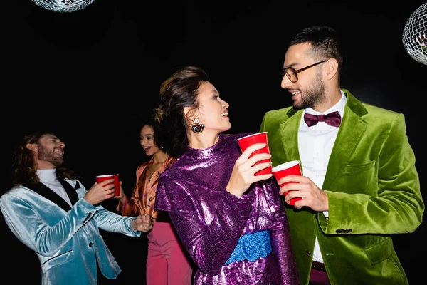 Smiling Multiracial Couple Plastic Cups Dancing Friends Black Background — Stock Photo, Image