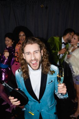 Gri arka planda, gece kulübünde ırkçı arkadaşlarla dans eden pozitif bir adam.