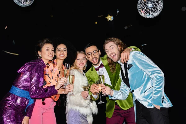 Playful Multiracial Friends Hugging Glasses Champagne Black Background — Stock Photo, Image