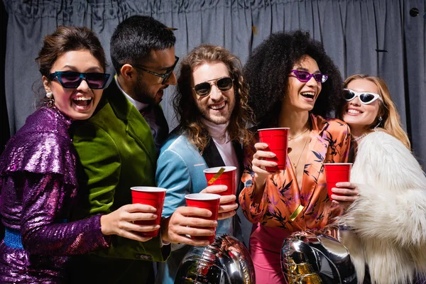 Happy Interracial Friends Sunglasses Celebrating Plastic Cups Grey Background — Stock Photo, Image