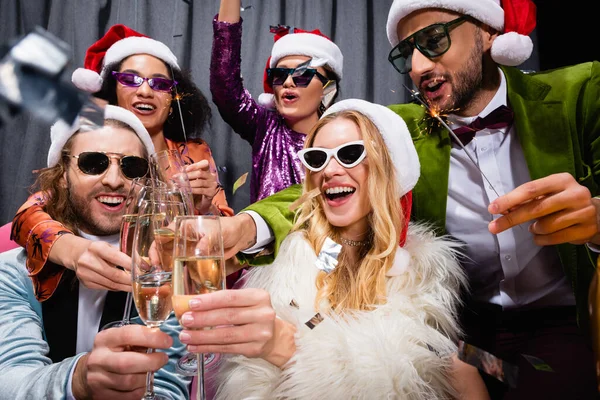 Sonrientes Amigos Interracial Sombreros Santa Celebrando Año Nuevo Cerca Cortina — Foto de Stock