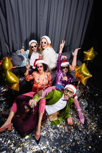 Amigos Interraciales Juguetones Sombreros Santa Celebrando Año Nuevo Cerca Cortina — Foto de Stock