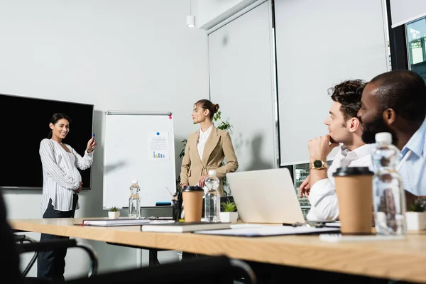 Schwangere Afrikanisch Amerikanische Geschäftsfrau Steht Neben Flipchart Und Verschwommenen Kollegen — Stockfoto